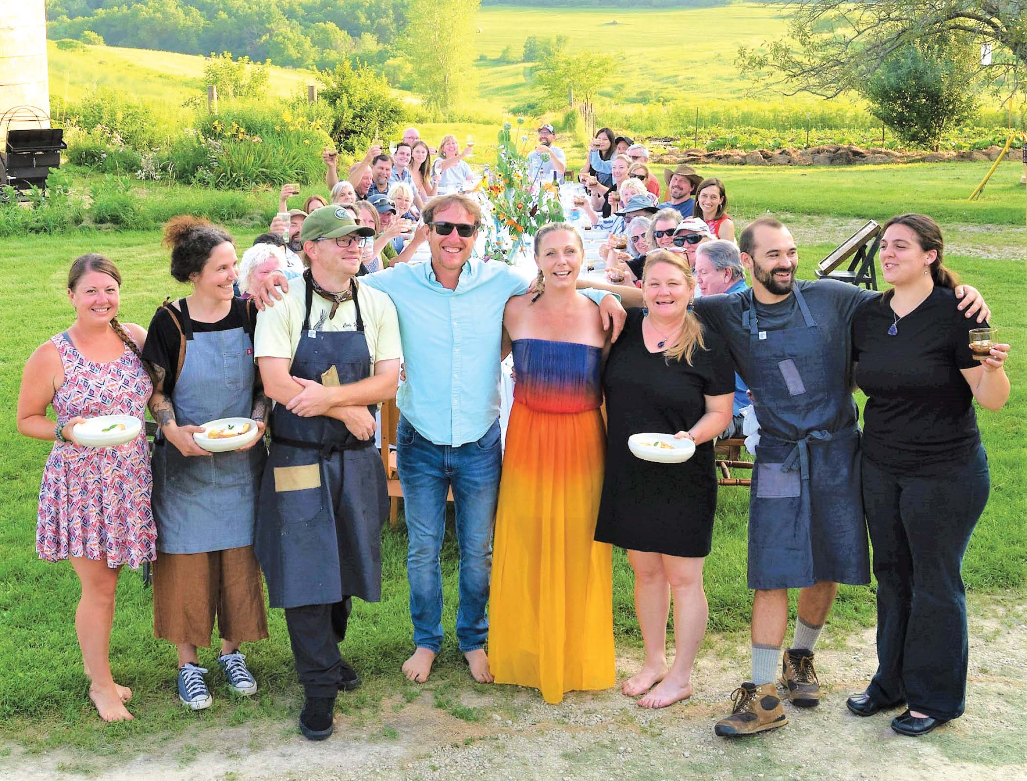 Rufus and Joy stand at center of a group during one of the Sunset Farm Dinners that are occasionally hosted at the Driftless Curiosity farm