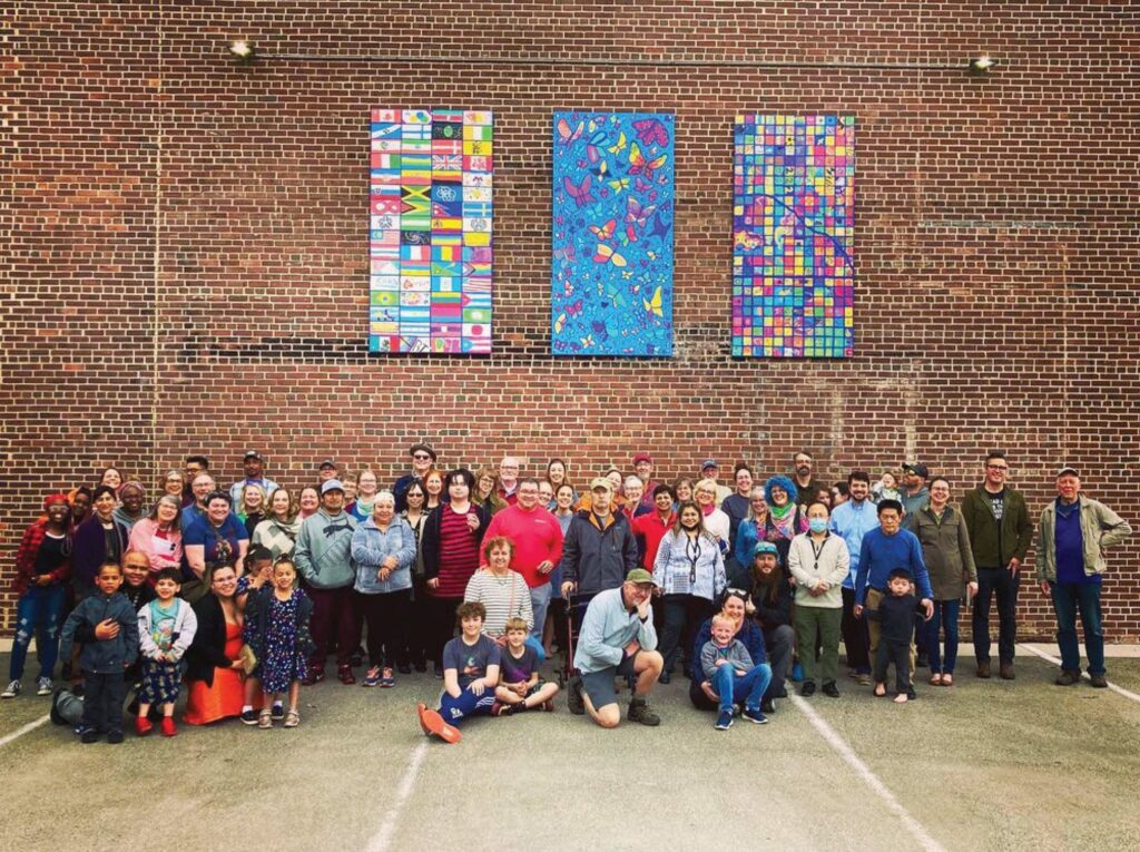 A large group of people including Sarah Johnson pictured at the Fabric of Winona installation