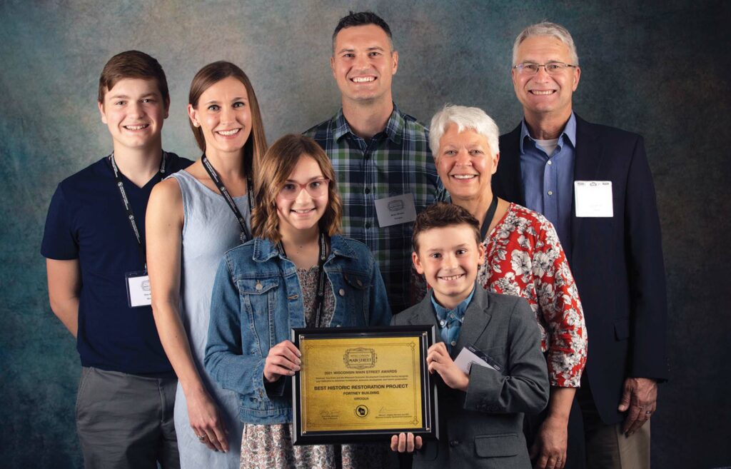 The Wrobel Family poses with their Main Street Wisconsin Award: Best Historic Restoration Project of 2021